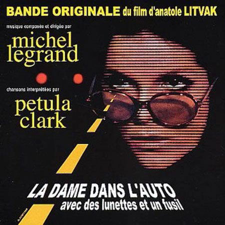 La dame dans l’auto avec des lunettes et un fusil